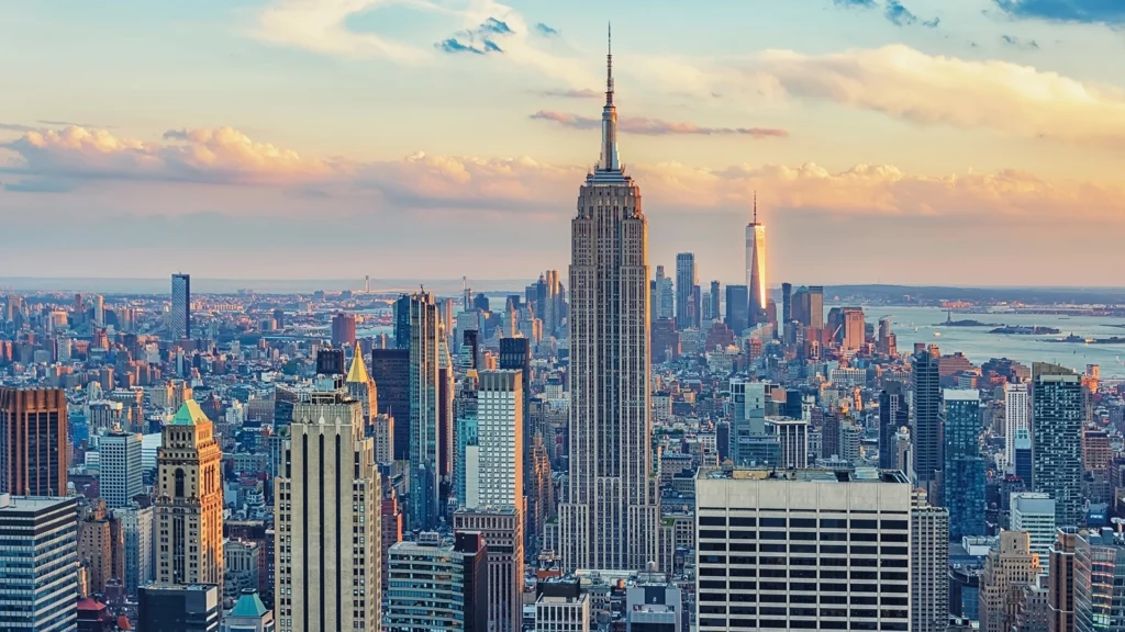 An aerial view of the Manhattan skyline, where the Empire State Building rises high above the skyscrapers