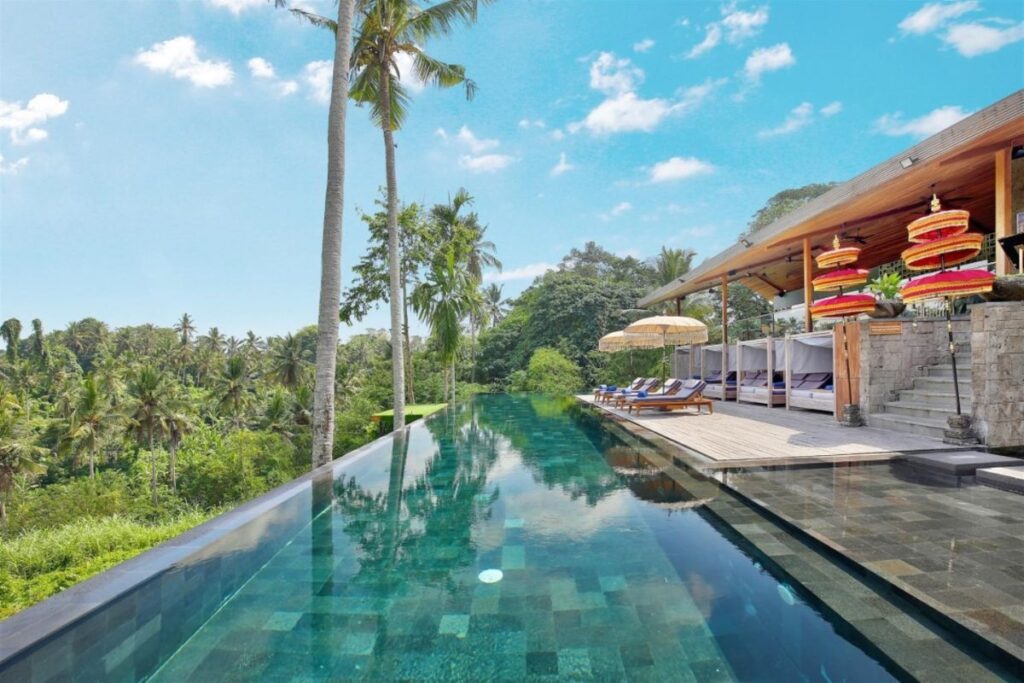 The jungle-facing infinity pool at Kaamala Resort Ubud is the perfect place to lounge in the sun - Luxury Escapes