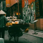 A street vendor in Hanoi rolls there cart of fresh fruit down a side street – one of many street vendors you'll encounter during a three-way stay in Hanoi.