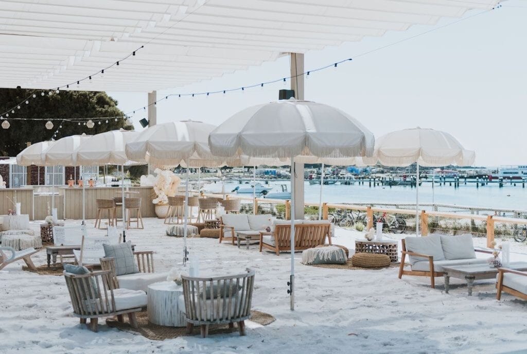 Beachside lounging with white umbrellas and coastal decor at Dream by Luxury Escapes.