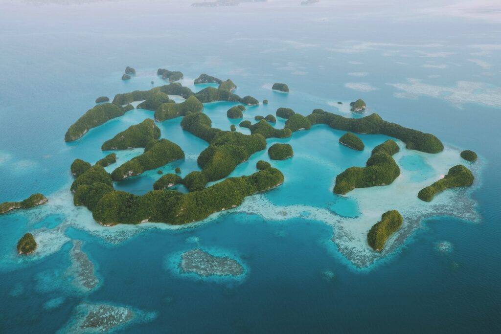 Lush green tropical islands surrounded by vibrant turquoise waters, ideal for luxury escapes and island holidays.