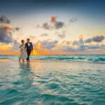 Bride and groom walking on the beach during a destination wedding