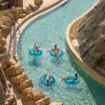 A family has a fun time in a lagoon pool at Yas Waterpark - Luxury Escapes