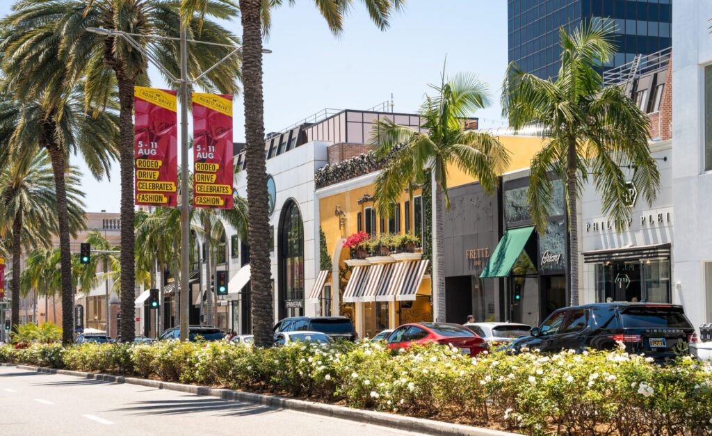Street scene on Rodeo Drive in Beverly Hills California with people and stores.
