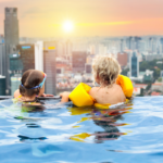 Picture of children in a rooftop swimming pool against Singapore skyline