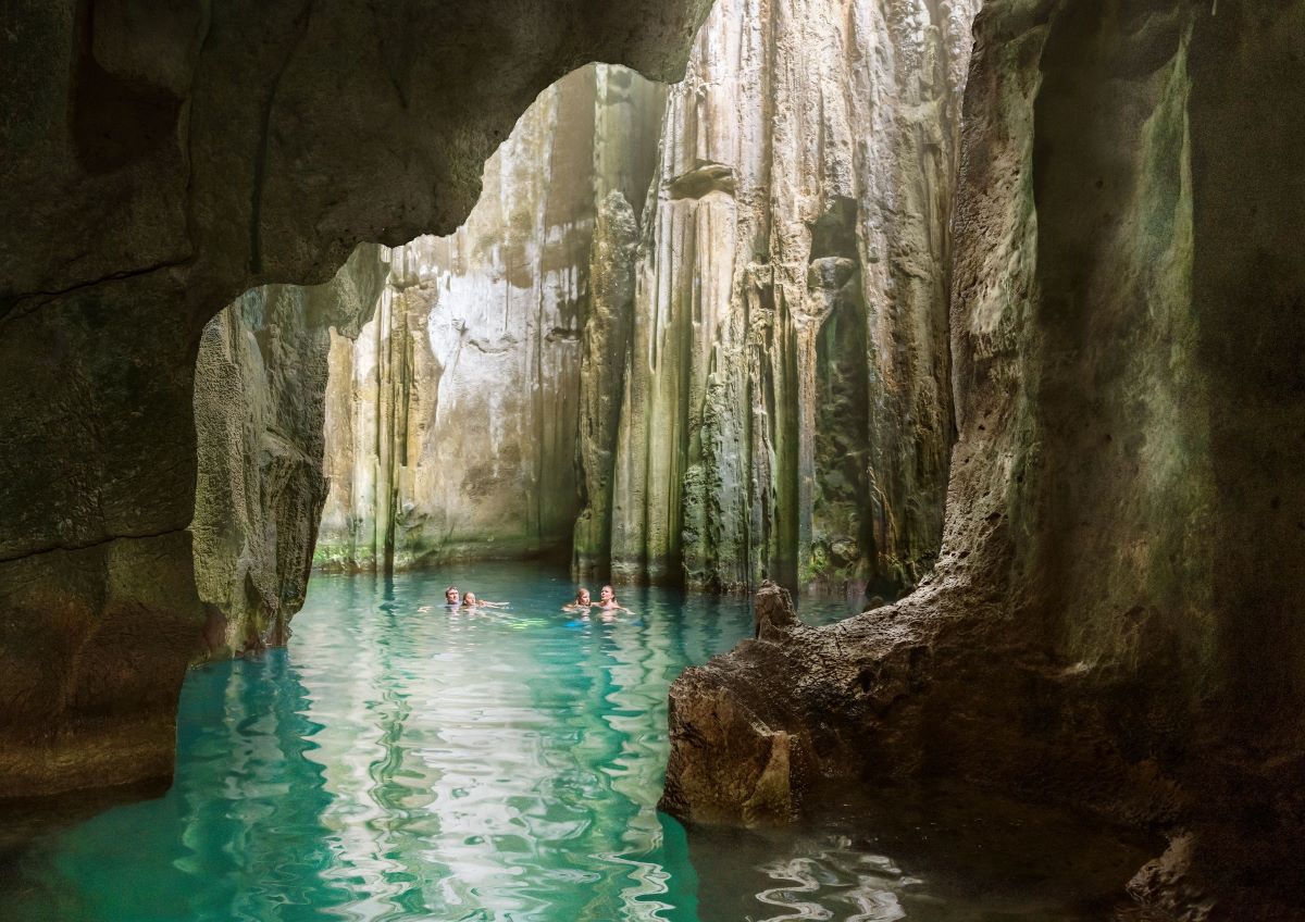 Family swimming in a cave on a Fiji holiday - Luxury Escapes