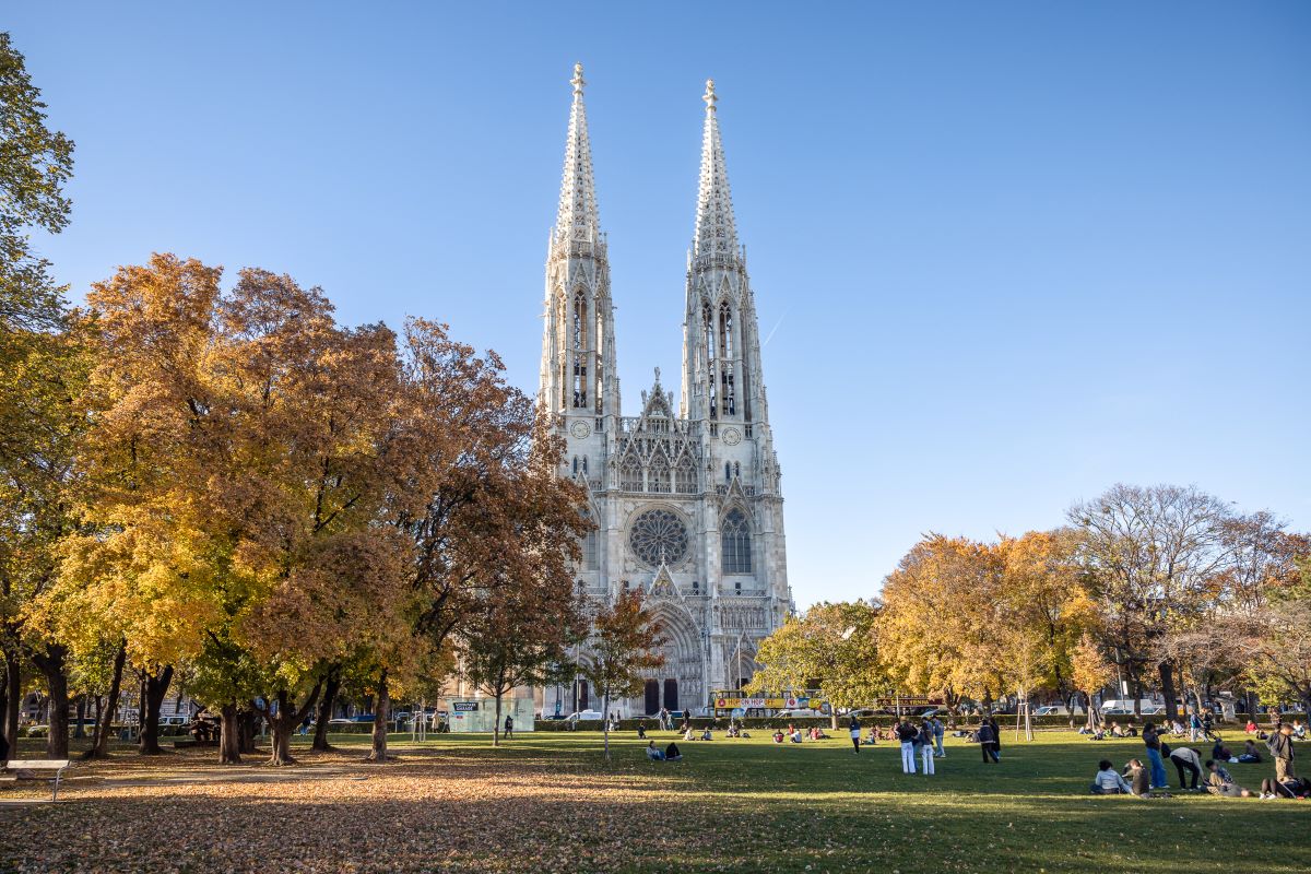 Sigmund Freud Park with a view of the Votive Church in autumn, to illustrate when to go to Vienna - Luxury Escapes