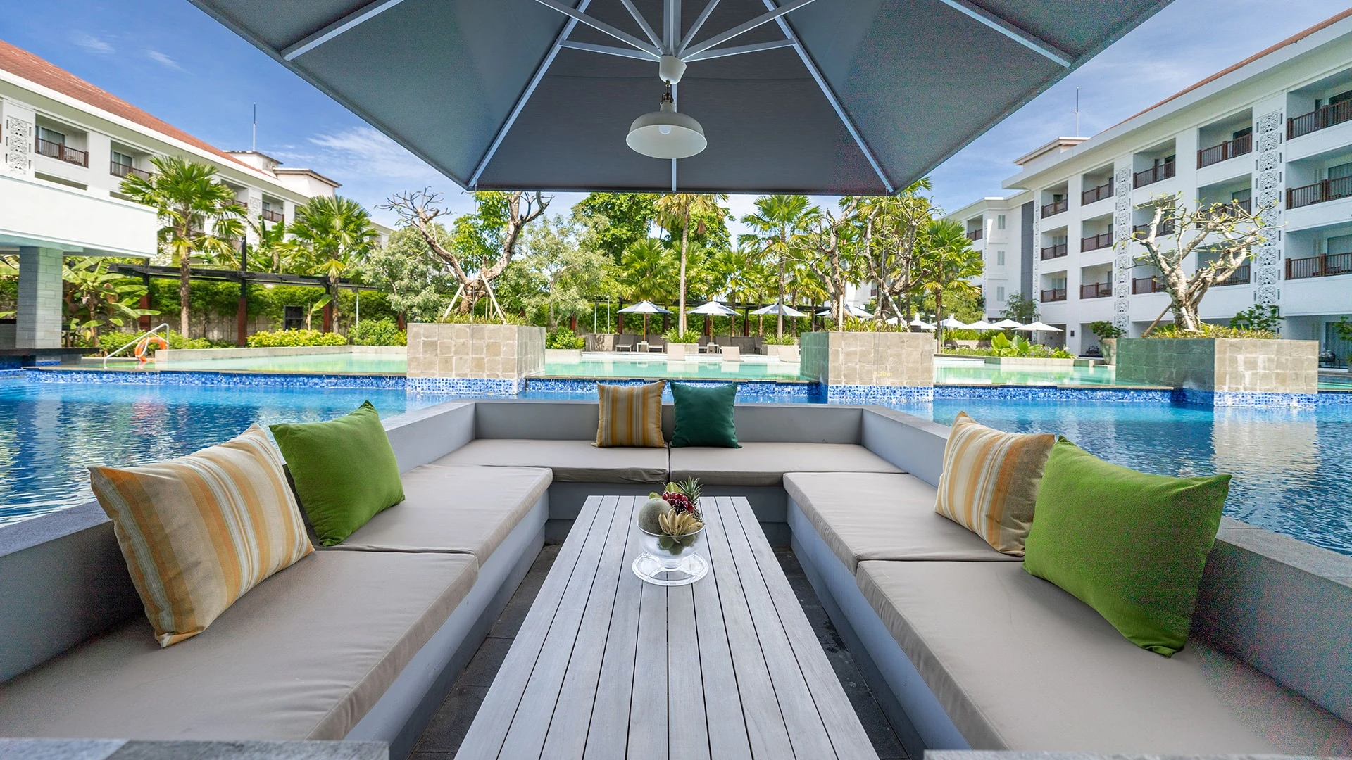 Seating by the pool at Grand Mercure Bali Seminyak - Luxury Escapes.