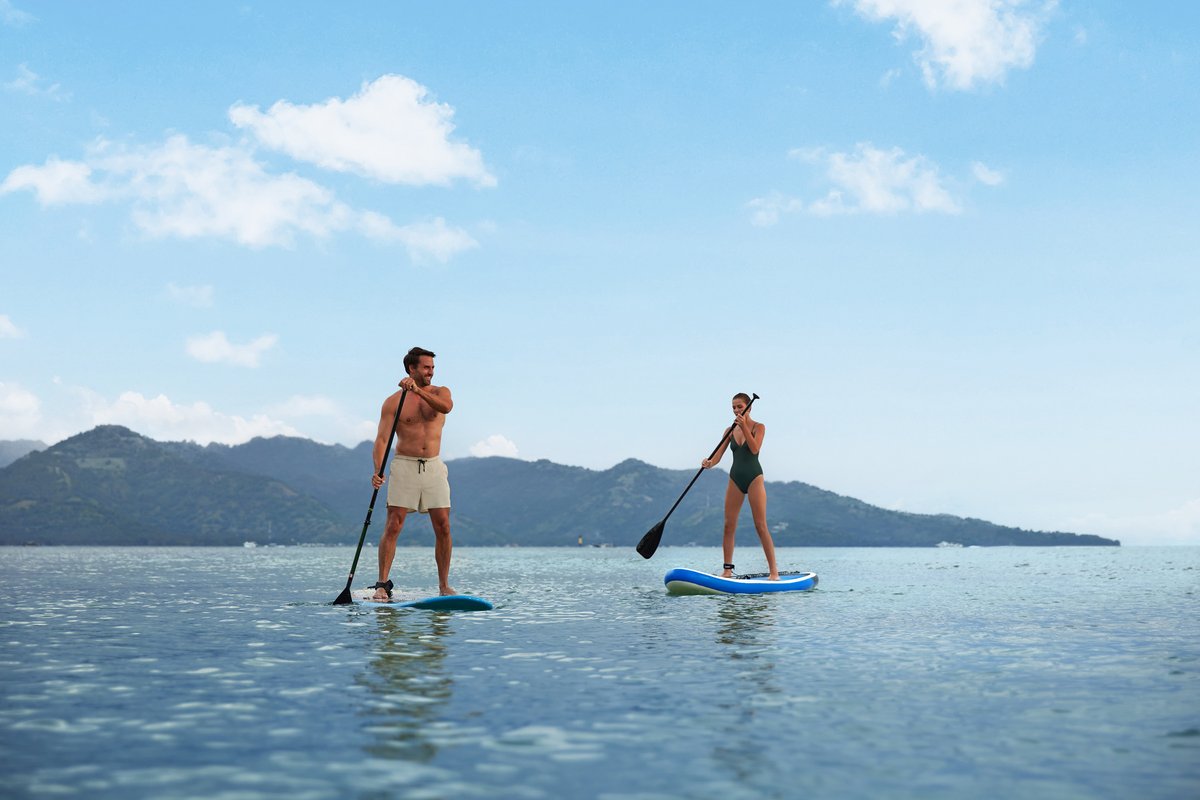 Guests stand-up paddleboarding near The Sira, Lombok.