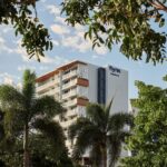 Crystalbrook Flynn hotel exterior, framed by palms, in Cairns Esplanade