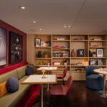 Hotel lounge with bookshelves, artwork and colourful seating at Hotel Indigo Sydney Potts Point, Sydney, New South Wales - Luxury Escapes.