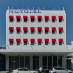 Novotel St Kilda hotel facade with red window awnings