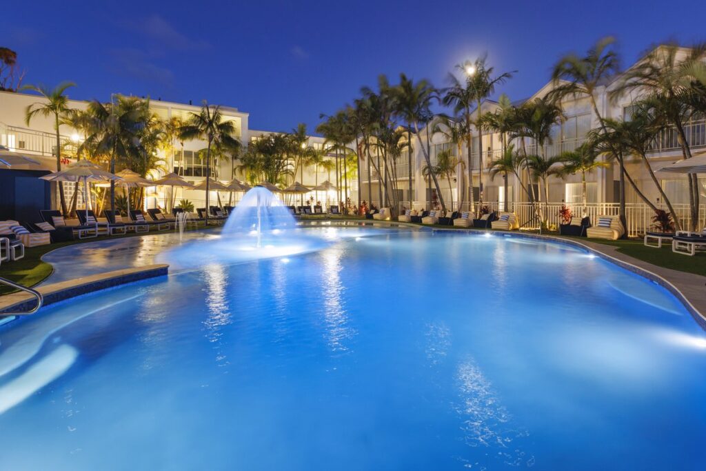 Outdoor pool illuminated at dusk at Ramada Resort by Wyndham Shoal Bay, NSW