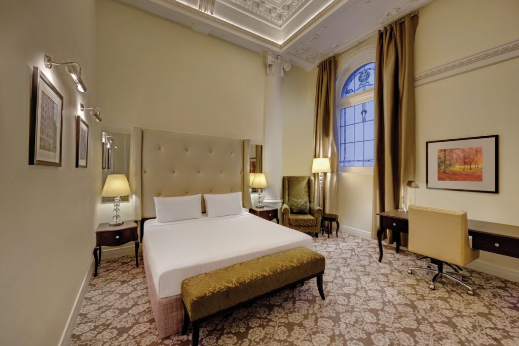 Heritage bedroom with arched window at Rendezvous Hotel Melbourne