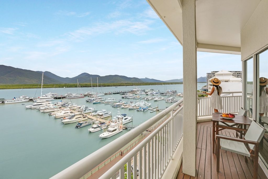 Guest on a suite balcony overlooking Cairns Marina at Shangri-La The Marina, Cairns