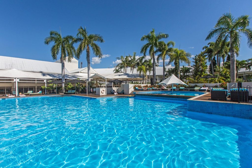Outdoor pool lined with palm trees at Shangri-La The Marina, Cairns