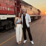 Hannah Hollis (left) and Cam Daddo (right) in front of the Ghan locomotive for Luxury Escapes TV.